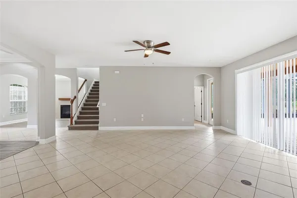 an empty room with wooden floor and ceiling fan