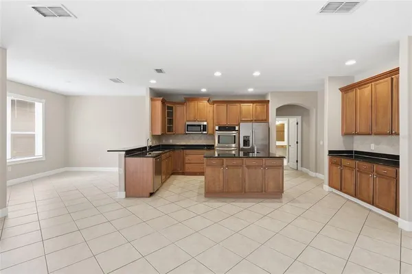 a kitchen with stainless steel appliances kitchen island granite countertop a stove a sink a microwave a counter top and cabinets