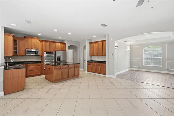 a large kitchen with stainless steel appliances a large counter top and a stove