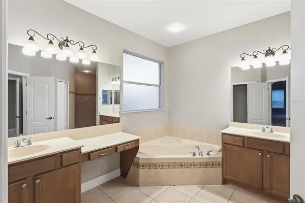 a bedroom with a large bed and a chandelier fan