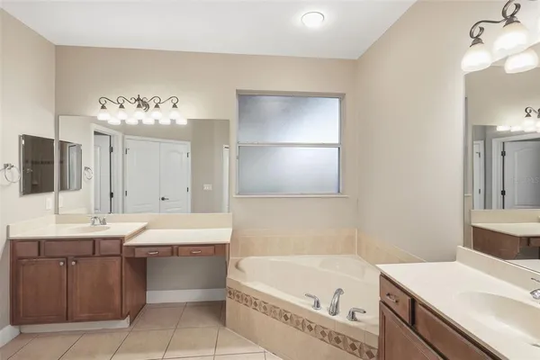 a bathroom with a tub sink and mirror