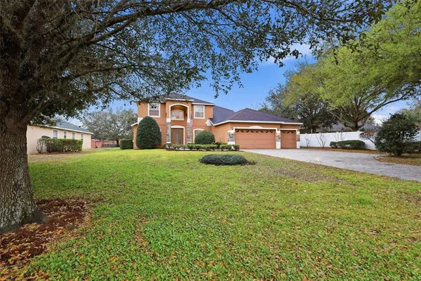 a front view of a house with yard and green space