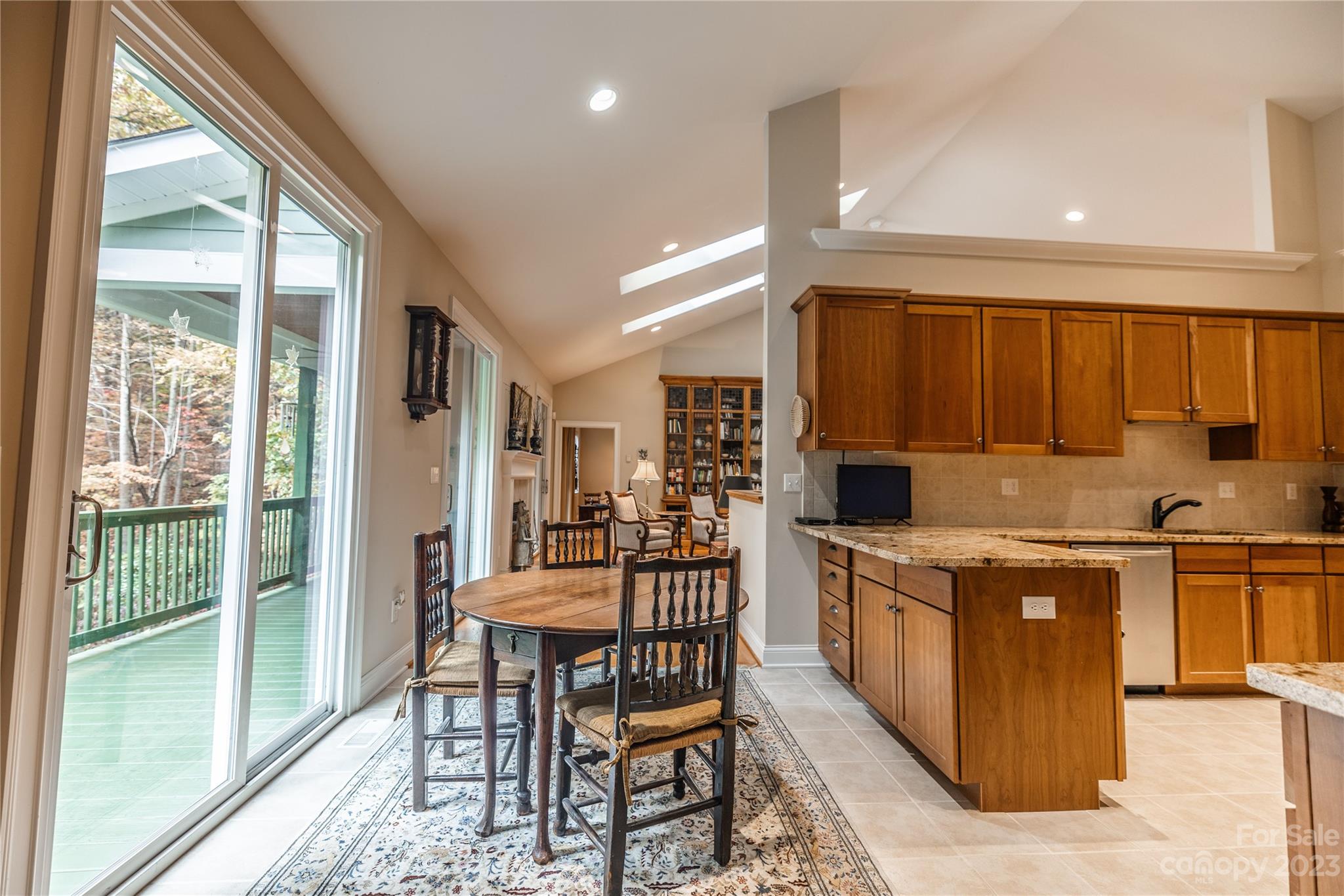 41 Silk Tree Road Hendersonville, NC 28739 - Photo 10 of 32 a kitchen with stainless steel appliances granite countertop a stove top oven a sink dishwasher a dining table and chairs with wooden floor
