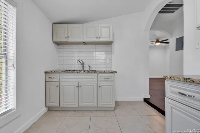 a kitchen with white cabinets and a stove