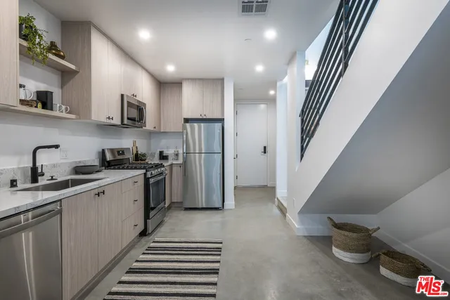 a kitchen with stainless steel appliances sink refrigerator and stove