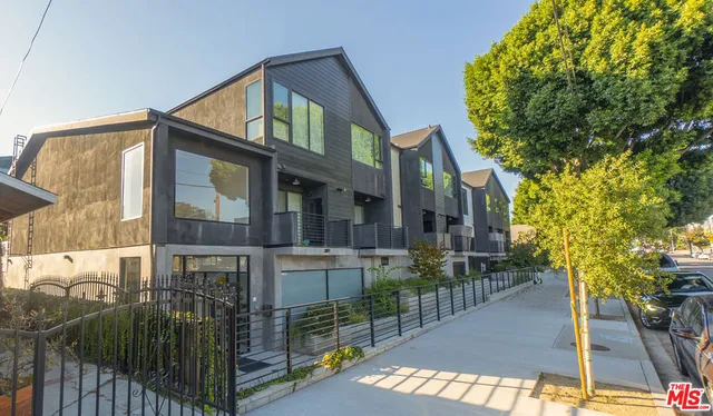 a front view of a house with glass windows and garden