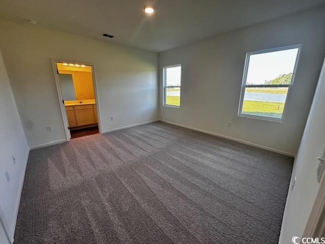219 Linares Street Loris, SC 29569 - Photo 8 of 10 Unfurnished bedroom featuring dark carpet and ensu