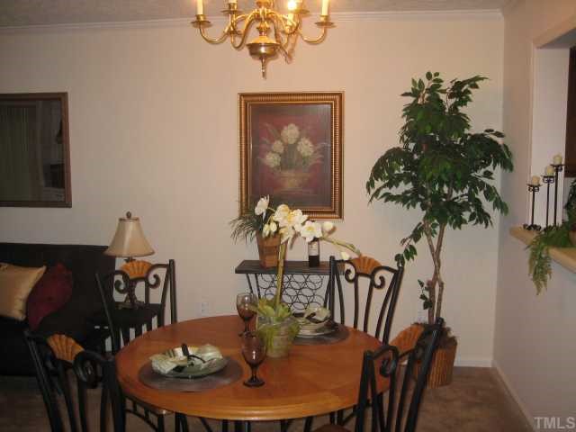 306 Broad Leaf Circle Raleigh, NC 27613 - Photo 3 of 12 a view of a dining room with furniture wooden floor and chandelier