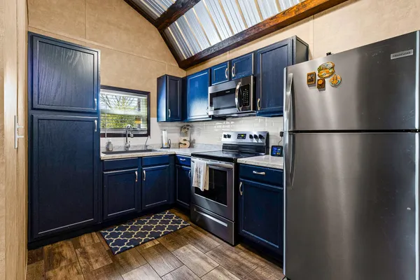 a kitchen with stainless steel appliances granite countertop a refrigerator stove a sink and a microwave