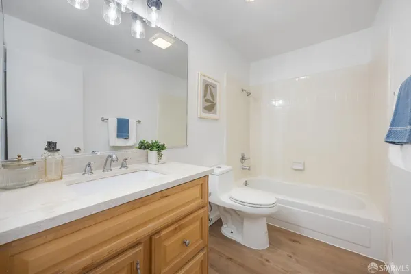 a bathroom with a granite countertop sink a toilet and bathtub