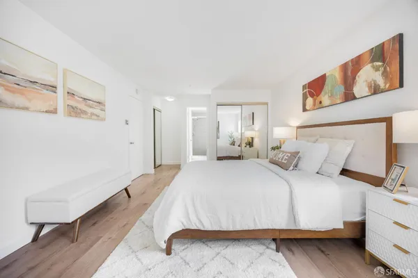 a bedroom with a bed and a painting on the wall