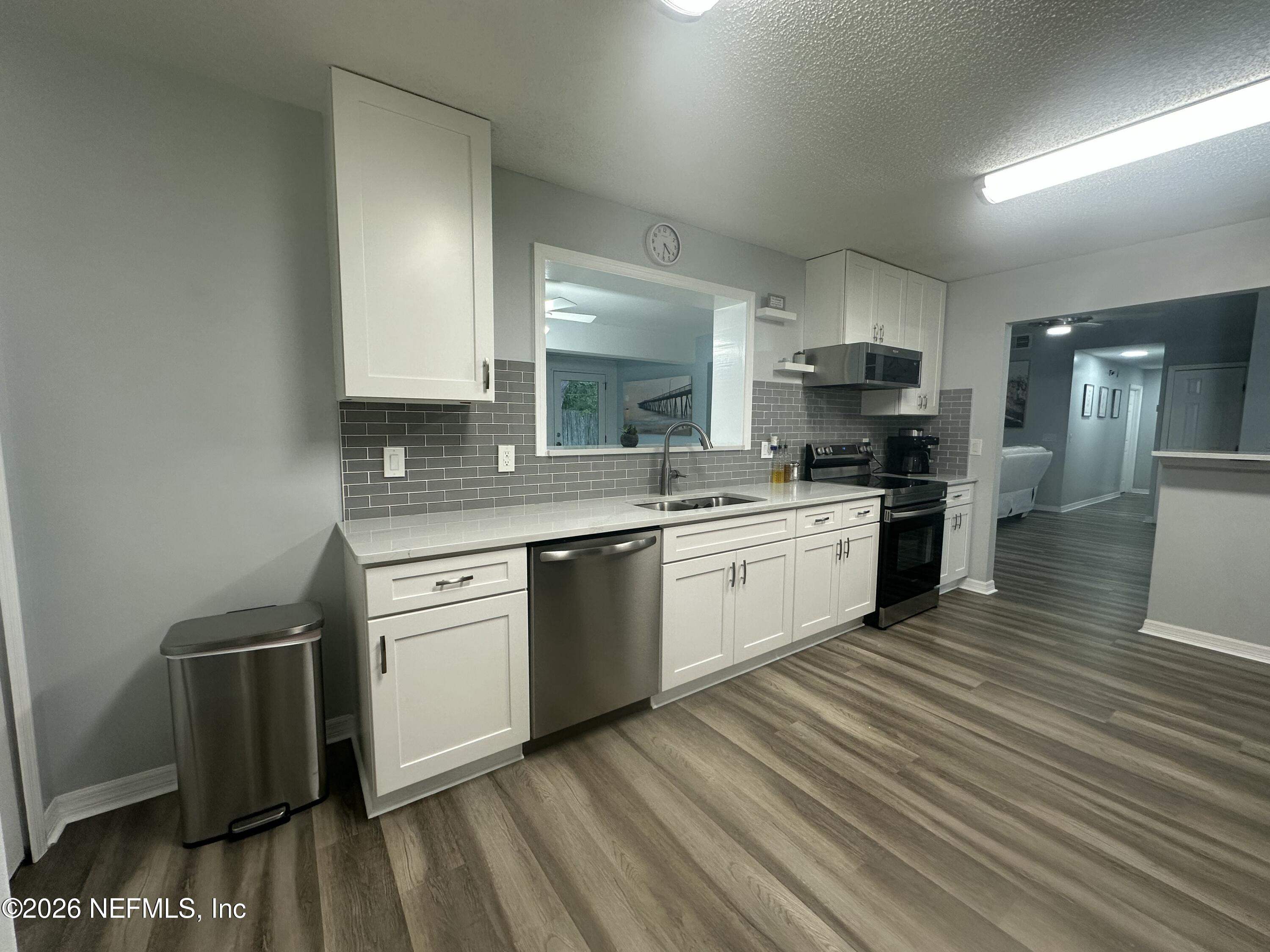 1516 Derringer Road Jacksonville, FL 32225 - Photo 23 of 55 a kitchen with a sink cabinets and wooden floor