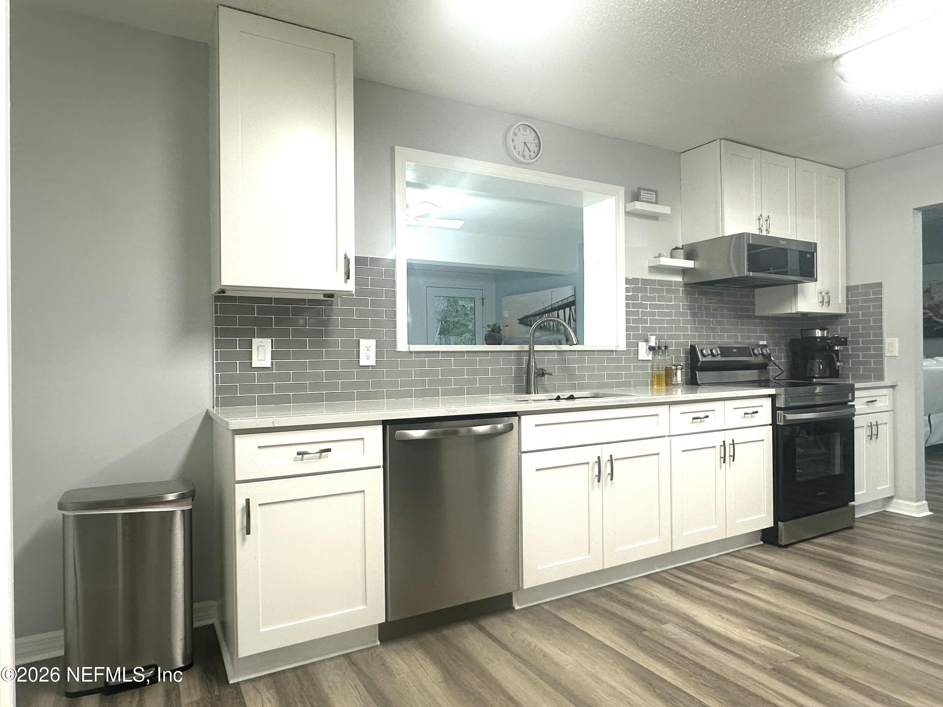 1516 Derringer Road Jacksonville, FL 32225 - Photo 25 of 55 a kitchen with stainless steel appliances granite countertop a stove a sink and a microwave