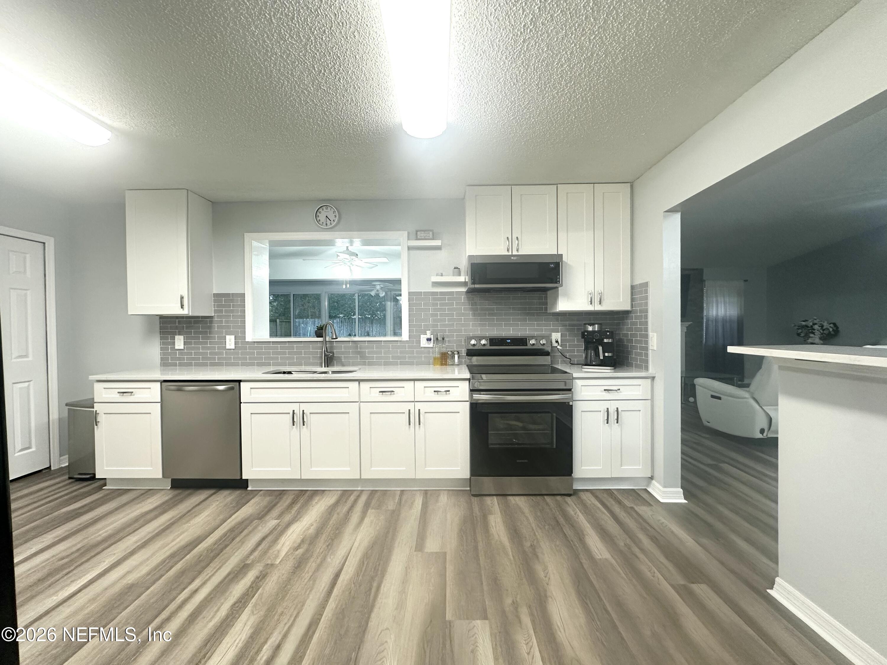 1516 Derringer Road Jacksonville, FL 32225 - Photo 27 of 55 a kitchen with a stove a sink and a refrigerator