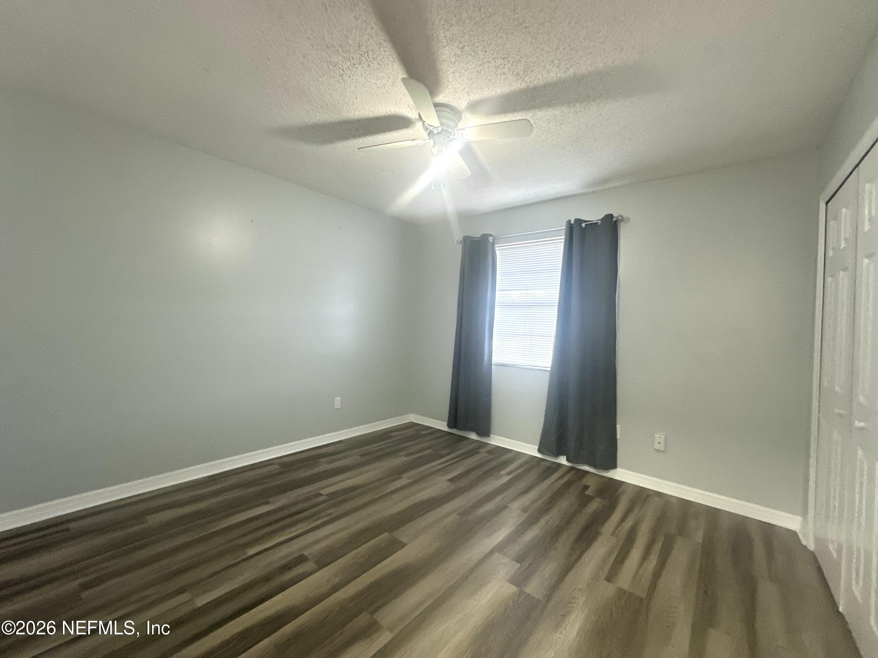 1516 Derringer Road Jacksonville, FL 32225 - Photo 35 of 55 wooden floor in an empty room with a window