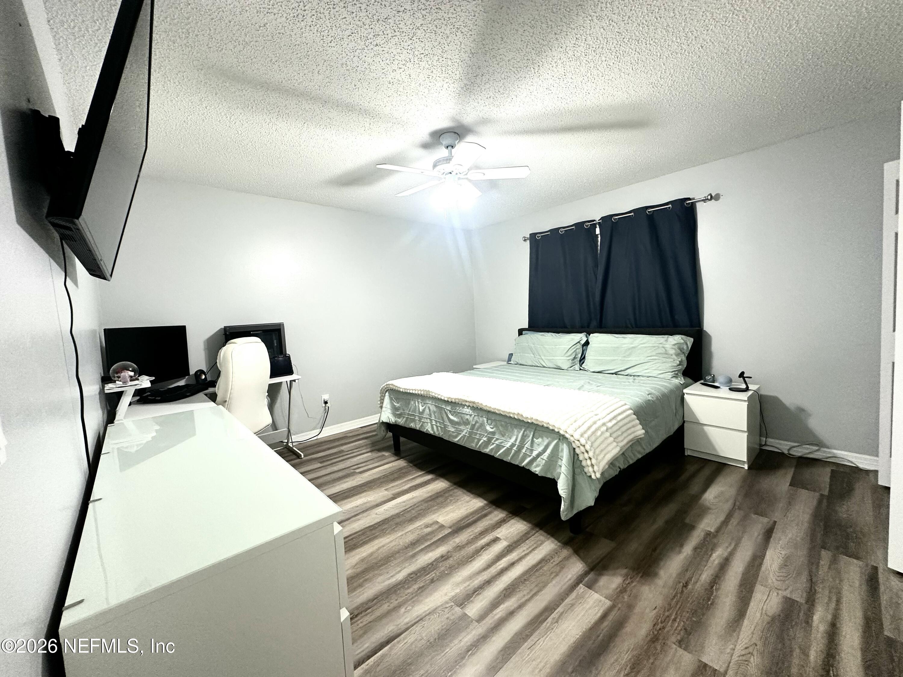 1516 Derringer Road Jacksonville, FL 32225 - Photo 41 of 55 a bedroom with bed and a flat tv screen on dresser