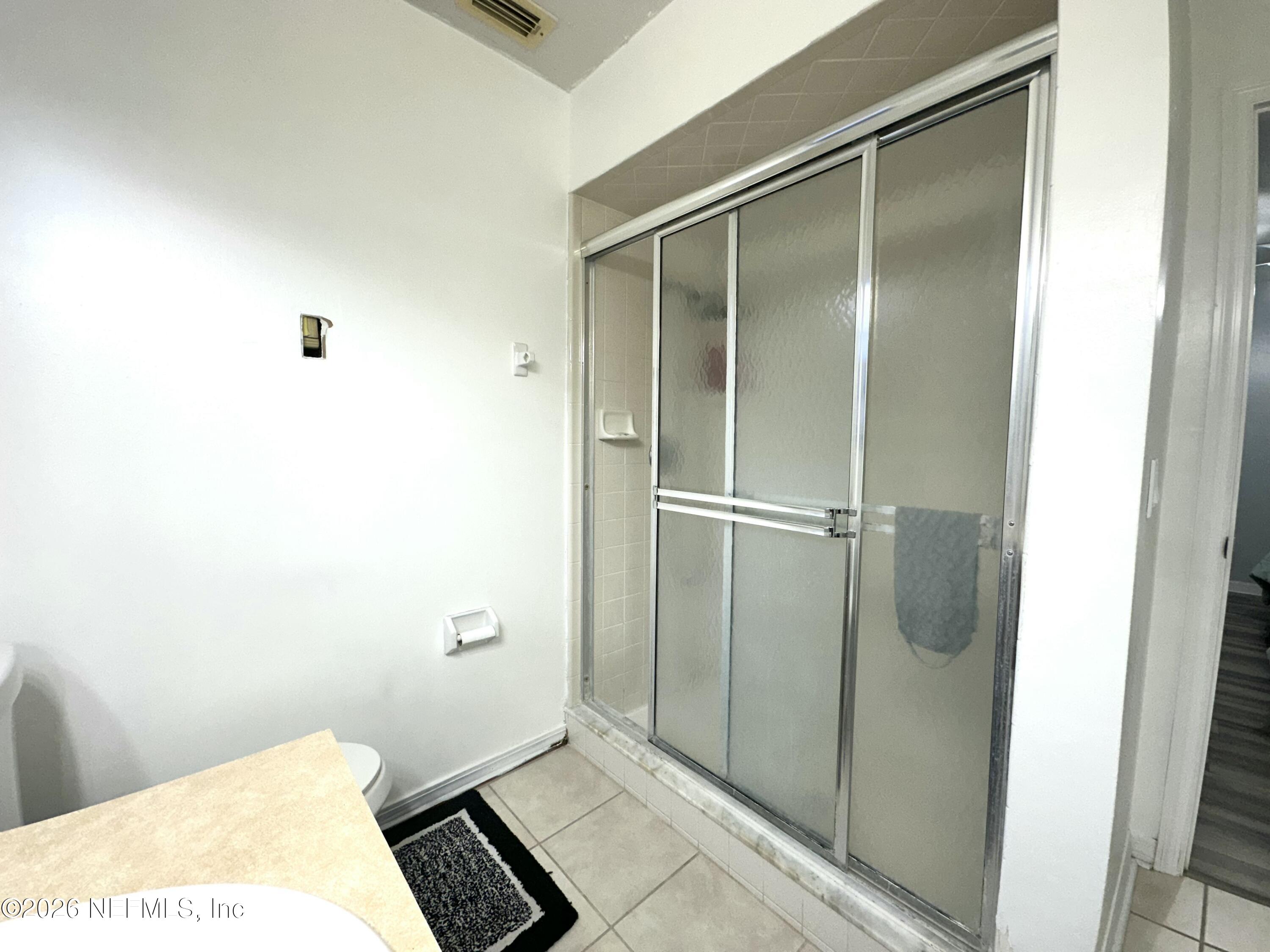 1516 Derringer Road Jacksonville, FL 32225 - Photo 47 of 55 a bathroom with a glass shower door