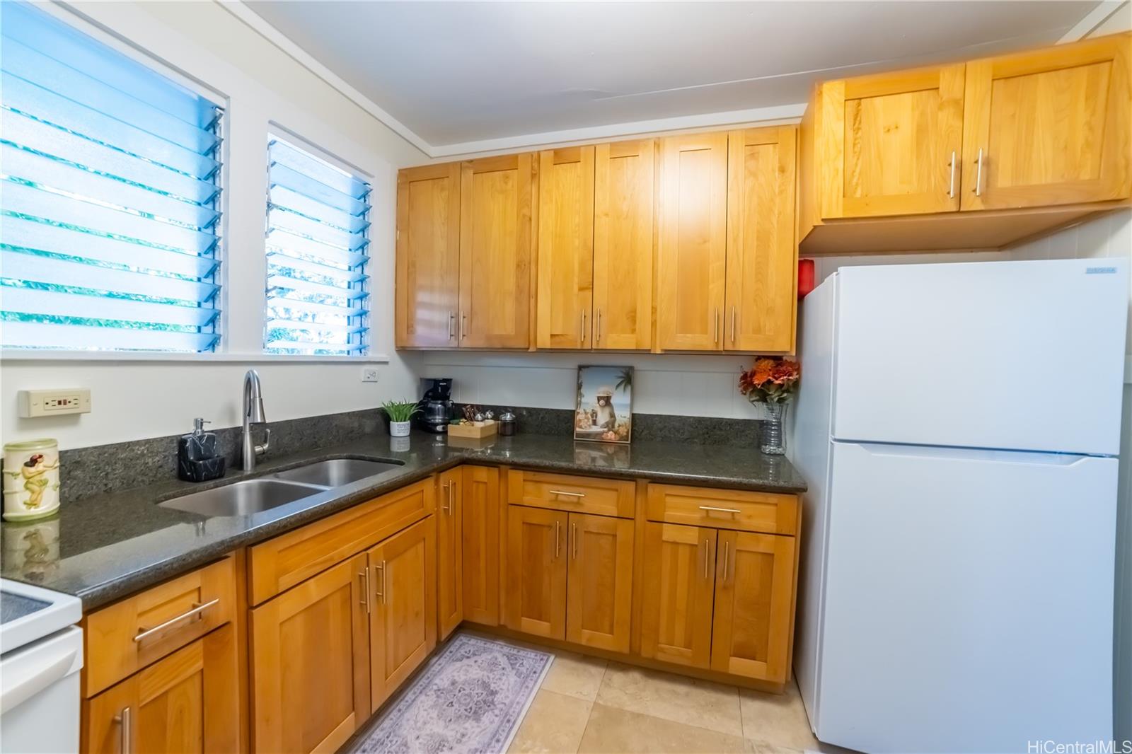 303 Wai Nani Way Honolulu, HI 96815 - Photo 17 of 24 a kitchen with granite countertop a sink a refrigerator and a window