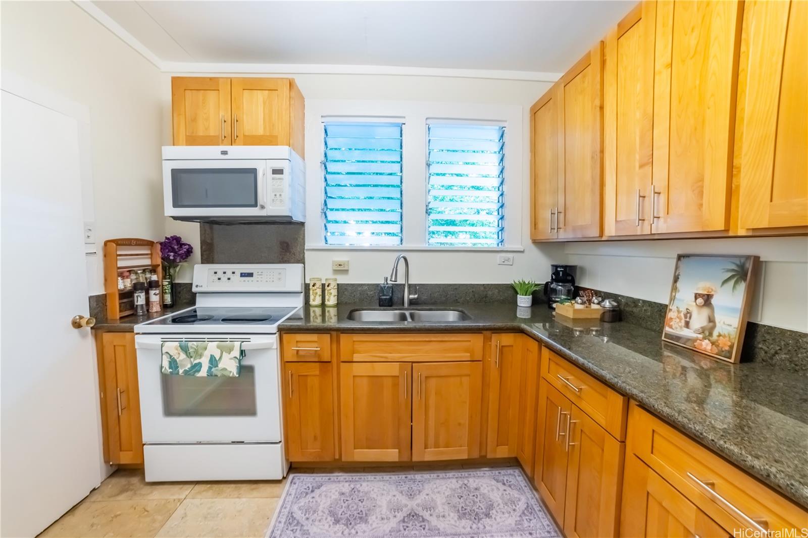 303 Wai Nani Way Honolulu, HI 96815 - Photo 18 of 24 a kitchen with stainless steel appliances granite countertop a sink and a window