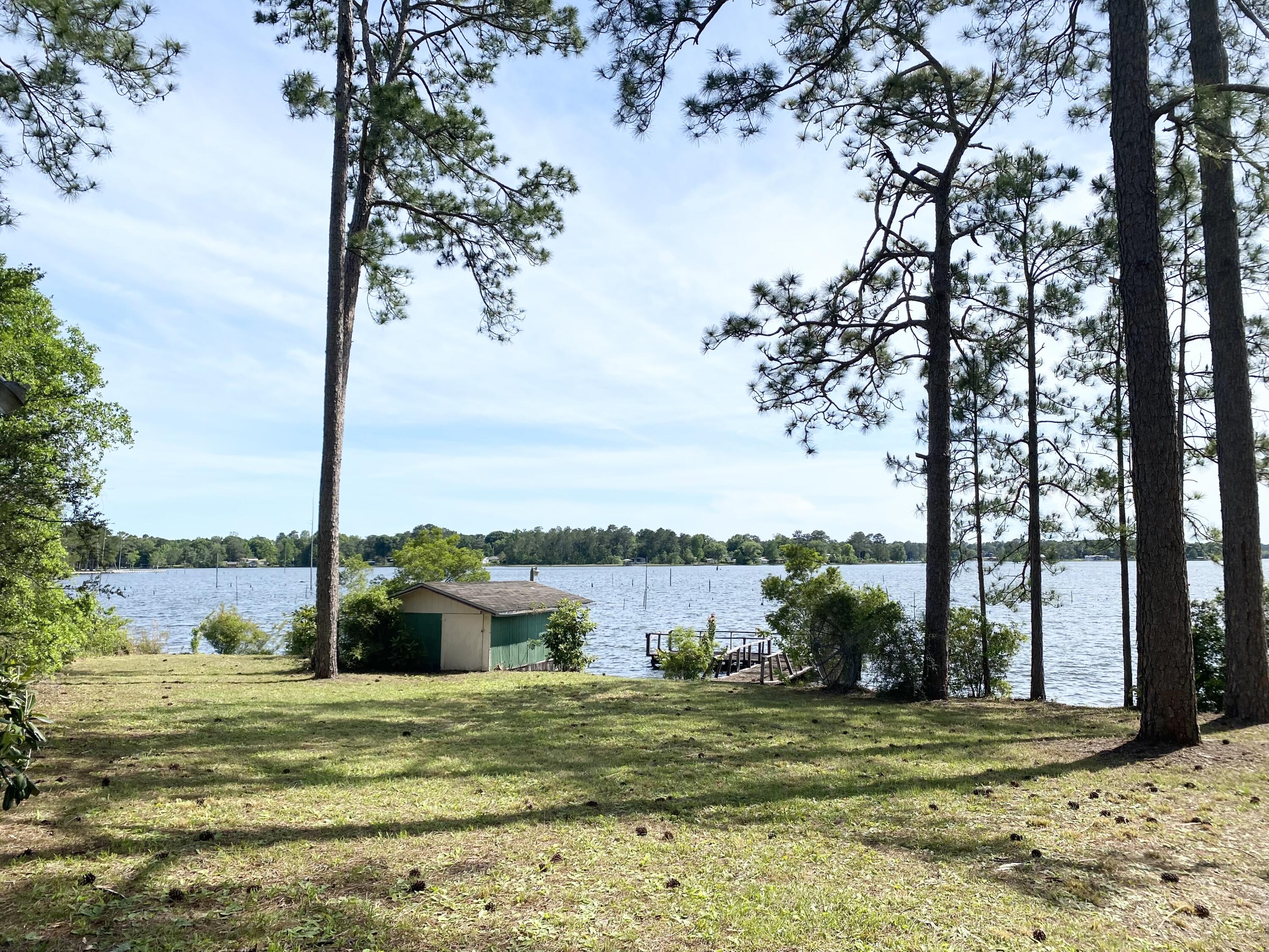 362 Wesley Road DeFuniak Springs, FL 32433 - Photo 8 of 10 a view of a white house with a yard and lake view