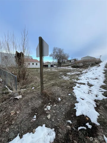 a view of a dry yard with wooden fence
