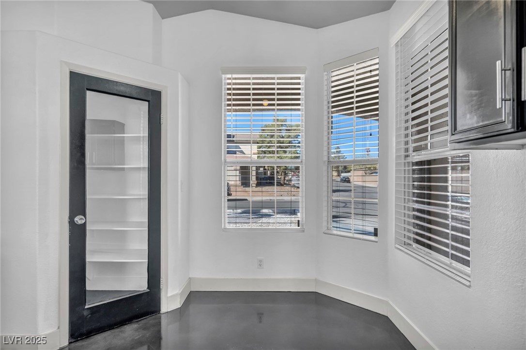 7308 Alpine Ridge Street Las Vegas, NV 89131 - Photo 14 of 47 Empty room with concrete floors and baseboards