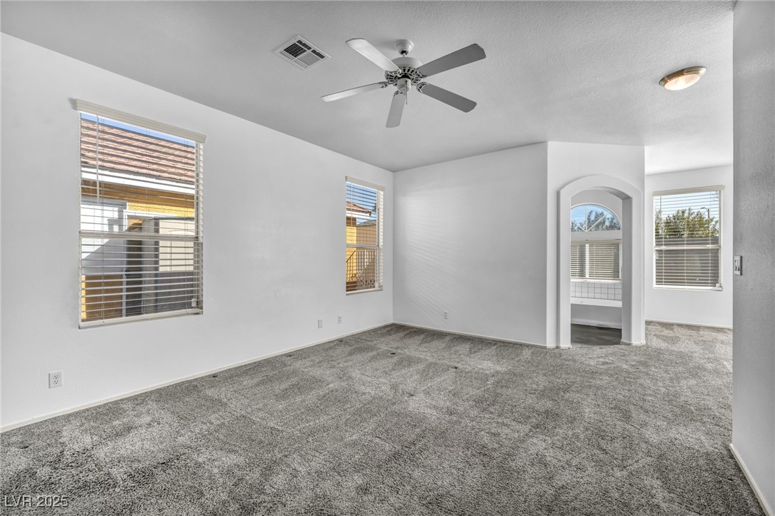 7308 Alpine Ridge Street Las Vegas, NV 89131 - Photo 16 of 47 Empty room with visible vents, ceiling fan, a textured ceiling, and carpet flooring