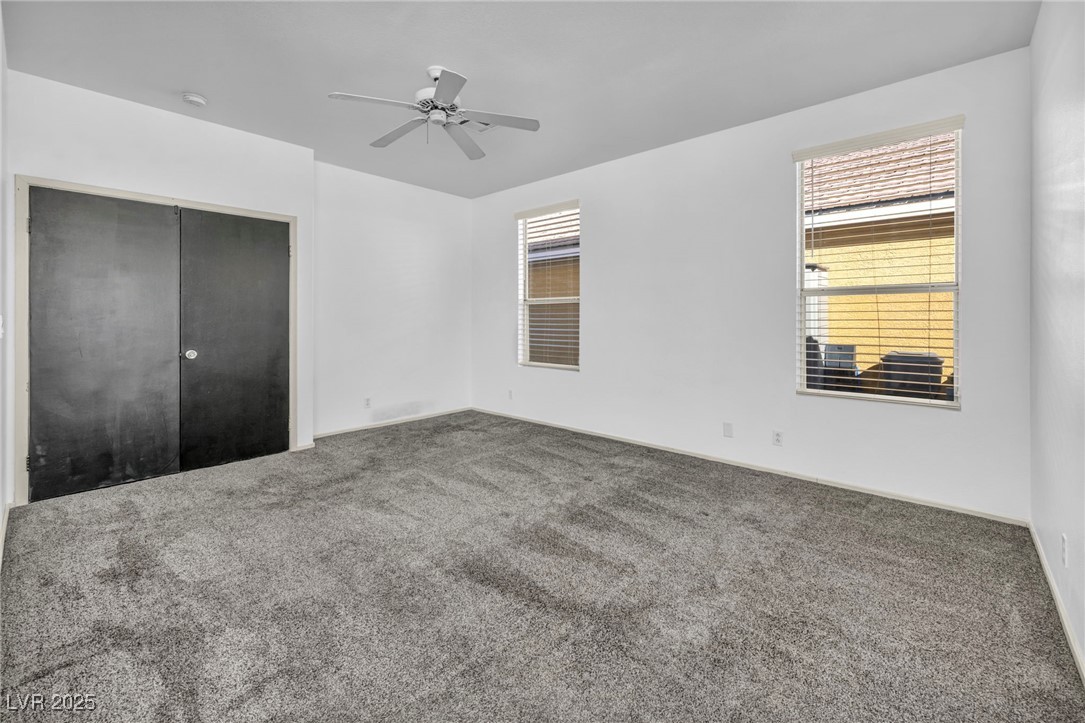 7308 Alpine Ridge Street Las Vegas, NV 89131 - Photo 18 of 47 Unfurnished bedroom with ceiling fan, a closet, and carpet flooring