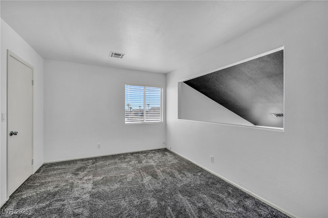 7308 Alpine Ridge Street Las Vegas, NV 89131 - Photo 30 of 47 Carpeted empty room with visible vents and a textured ceiling