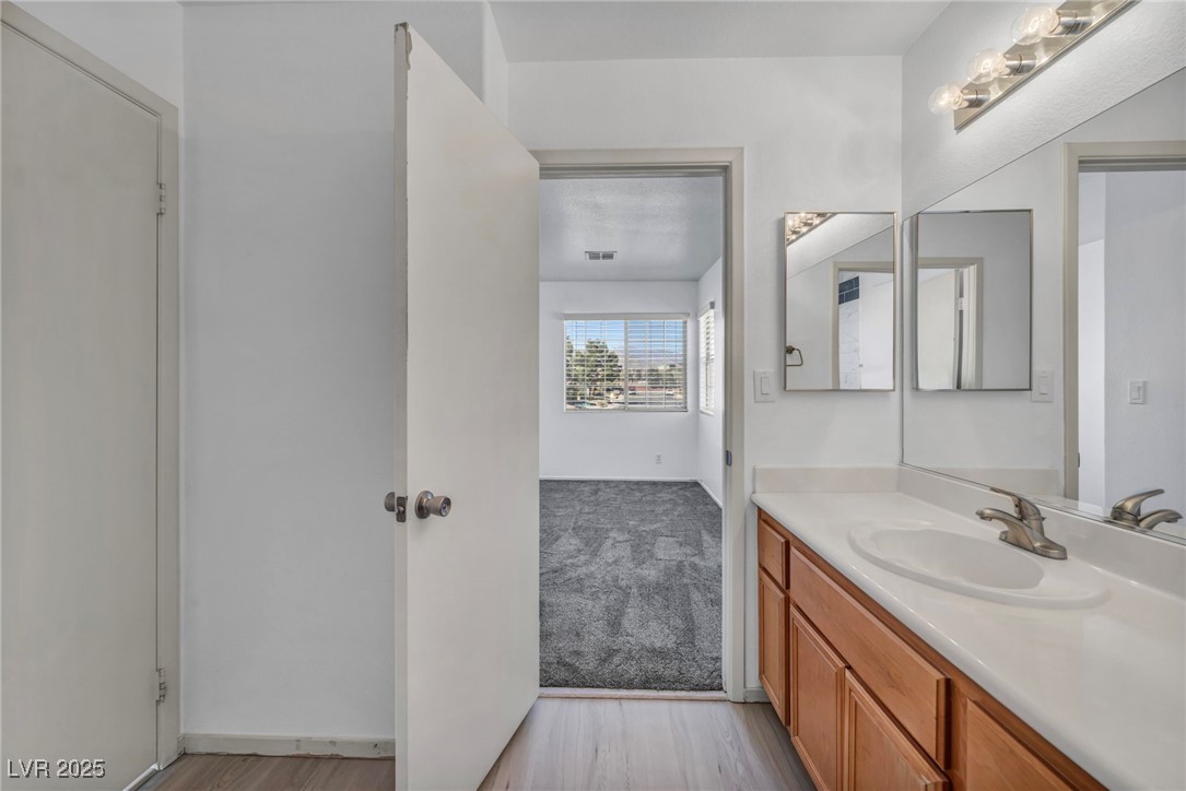 7308 Alpine Ridge Street Las Vegas, NV 89131 - Photo 34 of 47 Bathroom with visible vents, wood finished floors, and vanity