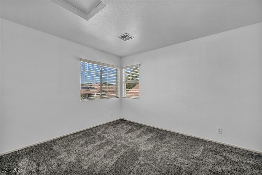 7308 Alpine Ridge Street Las Vegas, NV 89131 - Photo 36 of 47 Carpeted empty room featuring a textured ceiling and visible vents