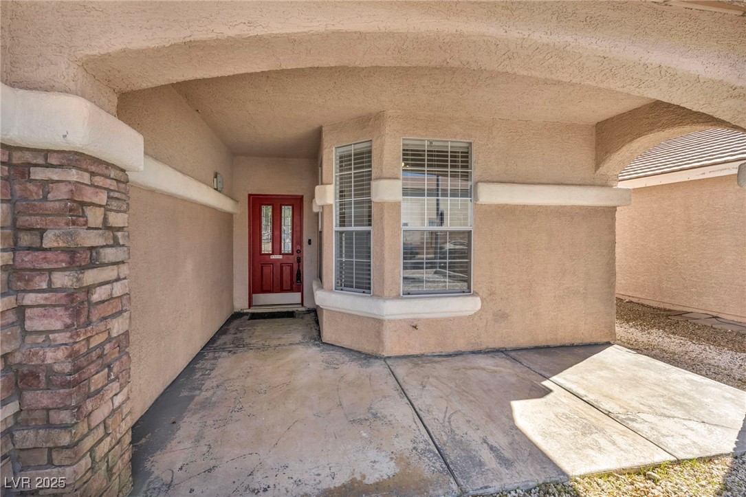 7308 Alpine Ridge Street Las Vegas, NV 89131 - Photo 4 of 47 Entrance to property with a patio area and stucco siding