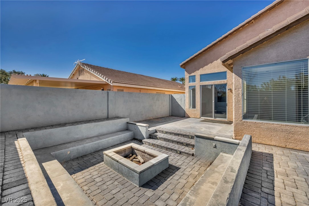 7308 Alpine Ridge Street Las Vegas, NV 89131 - Photo 41 of 47 View of patio featuring a fenced backyard and a fire pit