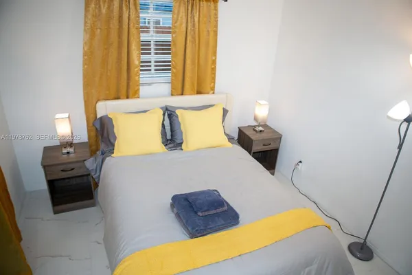 a bed sitting in a bedroom next to a window