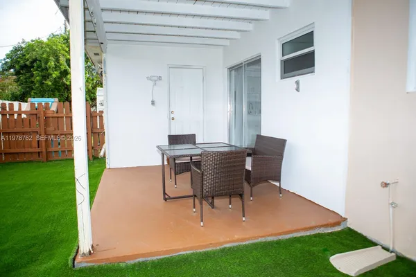 a view of a backyard with table and chairs with wooden fence
