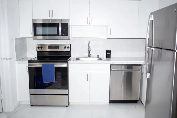 a kitchen with stainless steel appliances a stove microwave and refrigerator