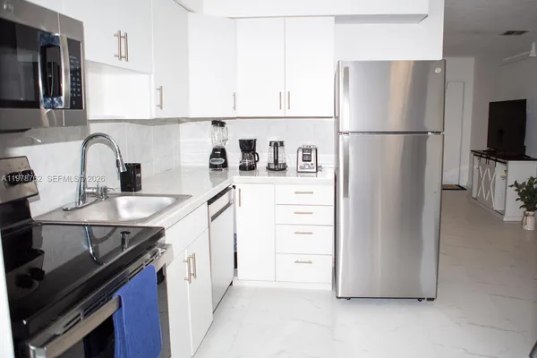a kitchen with stainless steel appliances a refrigerator sink and cabinets