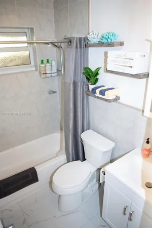 a white toilet sitting next to a bath tub