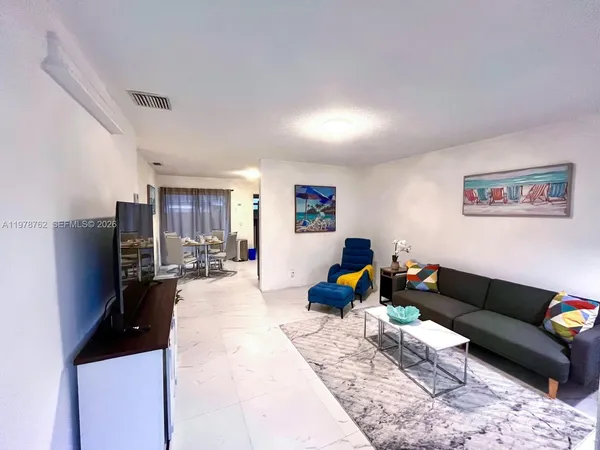 a living room with furniture wooden floor and a flat screen tv