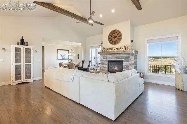 a living room with furniture a fireplace and a large window