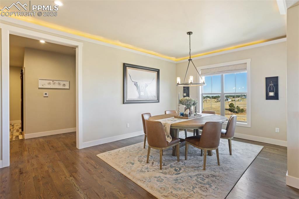 16835 Goshawk Road Colorado Springs, CO 80908 - Photo 19 of 50 a view of a dining room with furniture window and wooden floor