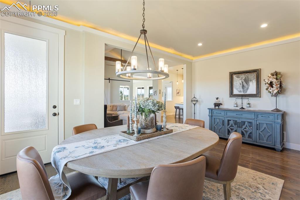 16835 Goshawk Road Colorado Springs, CO 80908 - Photo 20 of 50 a dining room with furniture a chandelier and wooden floor