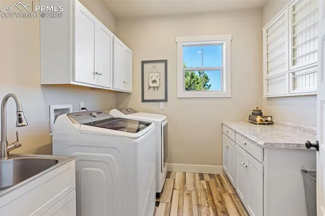 a utility room with sink dryer and washer