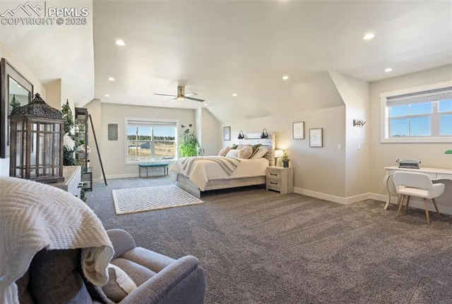 a spacious bedroom with a bed and a chair