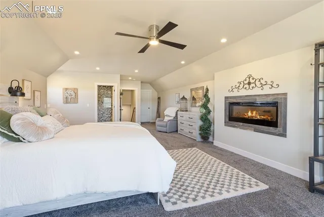 a spacious bedroom with a bed a mirror and a flat screen tv