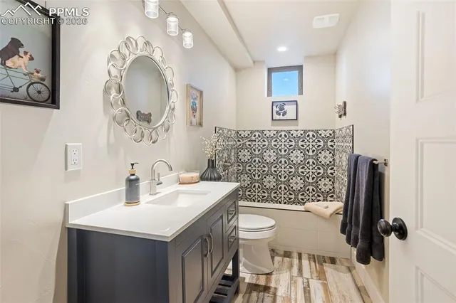 a bathroom with a sink mirror vanity and toilet