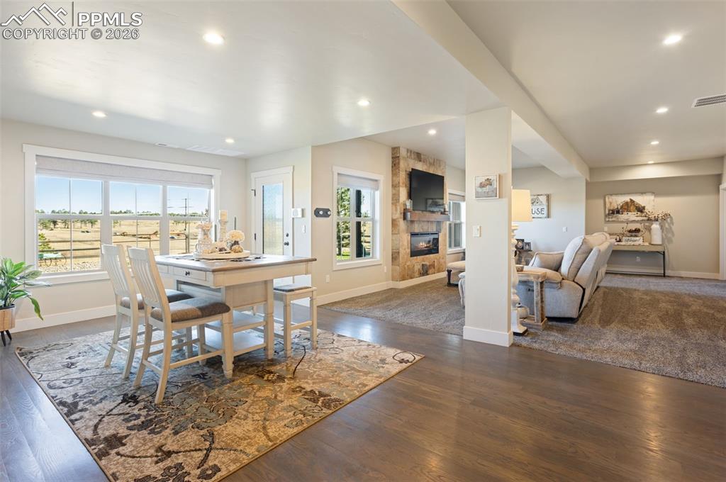 16835 Goshawk Road Colorado Springs, CO 80908 - Photo 34 of 50 a living room with furniture a dining table and kitchen view with wooden floor