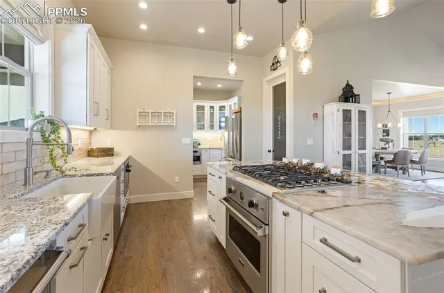 a kitchen with stainless steel appliances granite countertop a sink stove and refrigerator