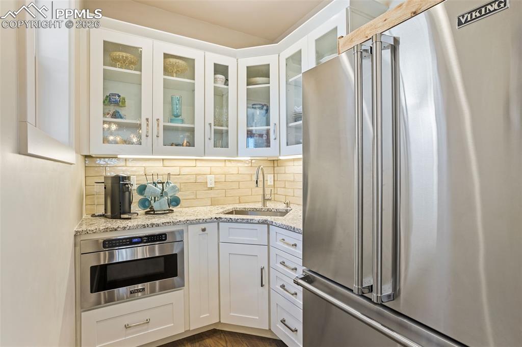 16835 Goshawk Road Colorado Springs, CO 80908 - Photo 10 of 50 a kitchen with granite countertop a refrigerator and a stove