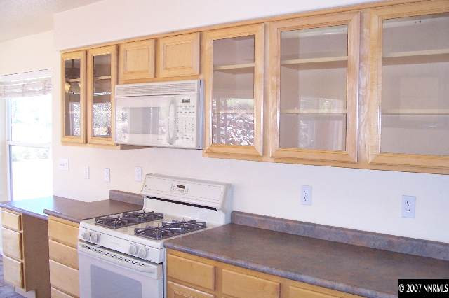 225 Koenig Road Reno, NV 89506 - Photo 5 of 9 a kitchen with stainless steel appliances granite countertop a stove and a white cabinets